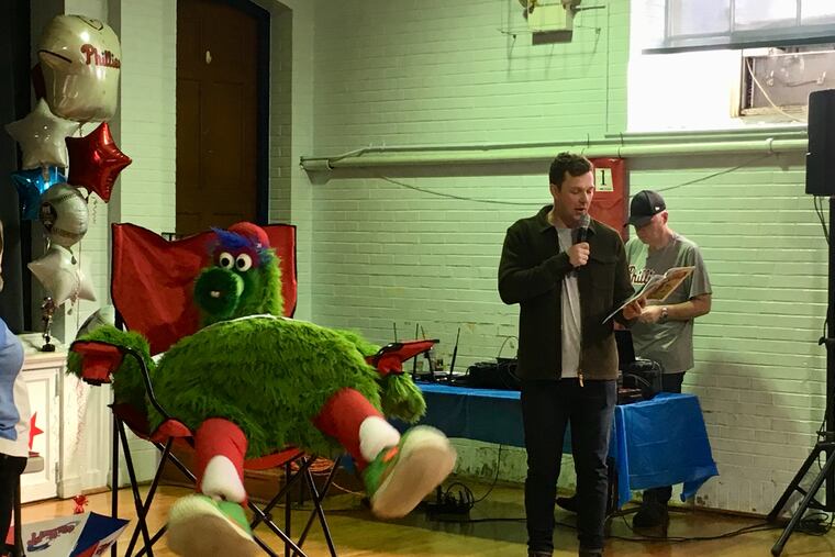 Phillies first baseman Rhys Hoskins, right, reads to students and the Phillie Phanatic, at St. Peter Cathedral School in Wilmington on Friday.