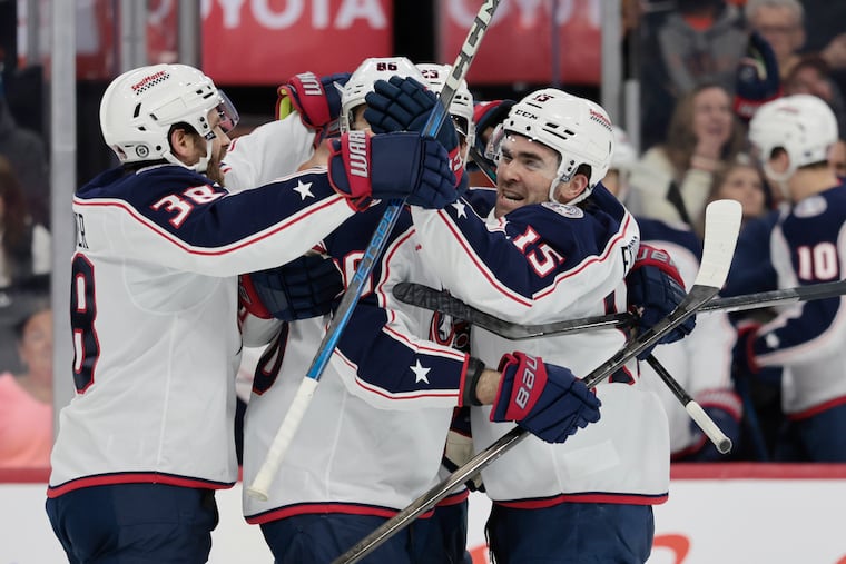Columbus Blue Jackets' Dante Fabbro (right) celebrates his second period goal against the Flyers on Tuesday.