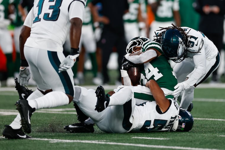 Eagles linebacker Jeremiah Trotter Jr. (bottom) and safety Andre' Sam stop Jets running back Kene Nwangwu during the first quarter.