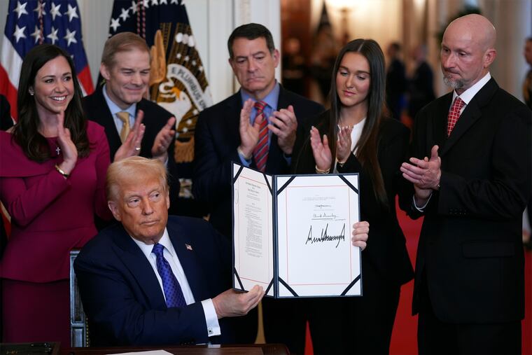 President Donald Trump holds the document after signing the Laken Riley Act during an event in the East Room of the White House on Wednesday.