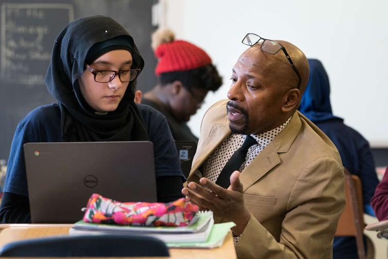 Tasneem Motan, left, and teacher Zahmu Sankofa, right, a middle-school teacher in Port Richmond, Sankofa is a singer and songwriter, he uses his background as an entertainer to keep students engaged, at James Martin MS, in Philadelphia, March 23, 2018. JESSICA GRIFFIN / Staff Photographer