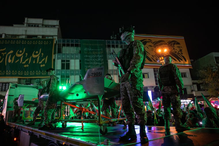 Members of Iran’s Islamic Revolutionary Guard stand near a drone display at a government-organized march last month in Tehran.