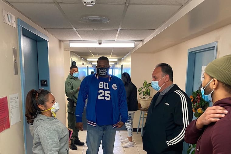 In a mayoral mask and Sixers gear, Atlantic City Mayor Marty Small Sr. campaigns in a high rise Sunday urging voters to reject an attempt to change the form of government. At right is City Council President George Tibbitt.