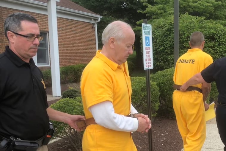 Ralph Miller, 71, is escorted out of district court in Doylestown on July 30 after a preliminary hearing. He's accused of sending explicit emails to an underage girl while in custody in federal prison.