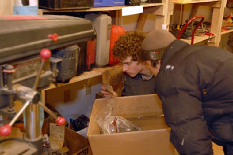 Pierre Sahmel (left) and Lane Davis, both from South Philadelphia, look through a box of free items at the Tool Library in West Phila. (Ron Tarver / Staff Photographer)