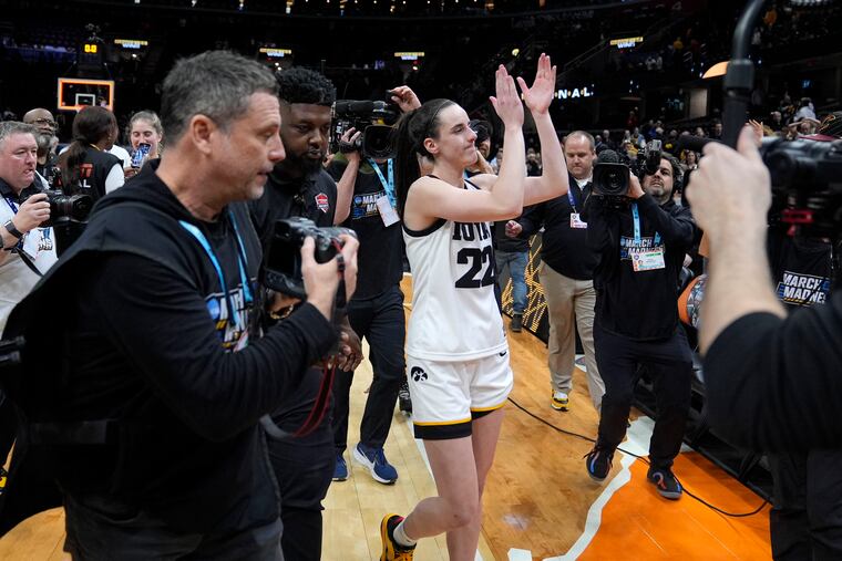 Iowa star Caitlin Clark applauds to the crowd as cameras surround her after the Hawkeyes' Final Four win over Connecticut.