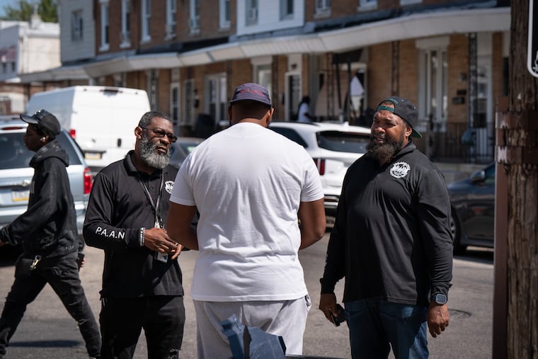 William Holmes (left) and Bahir Robinson, PAAN advocates in community crisis intervention, connect with residents.