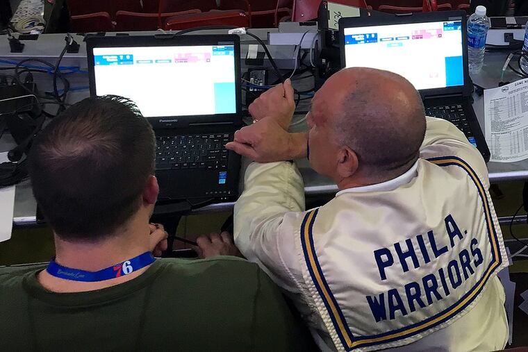 Sixers stat crew chief Ron Pollack wore an authentic Philadelphia Warriors warmup jacket while working at a recent game. Son Brian is to his left. MIKE JENSEN / Staff
