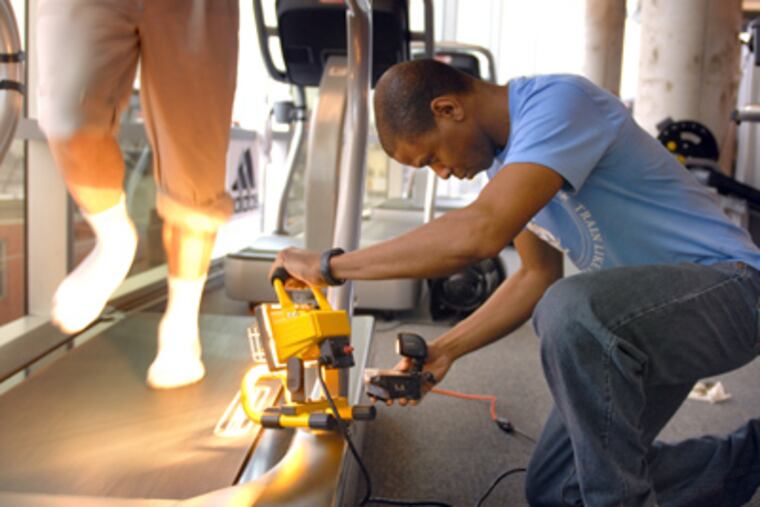 Using a high-speed digital video camera, Phil Clark records Art Carey's running gait on the treadmill at the Training Station. (Tom Gralish / Staff Photographer)