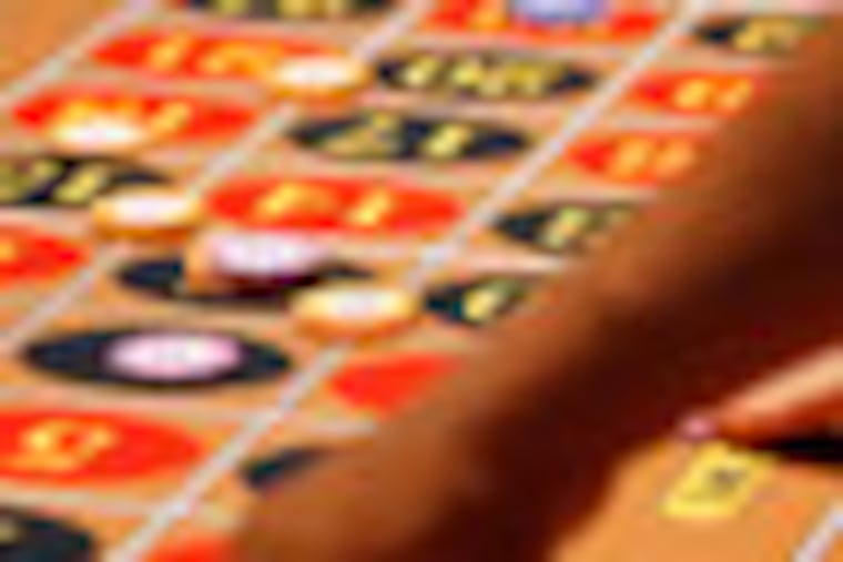 Gamblers place their bets on the roulette table during the first day of table games at Harrah's Casino in Chester, Pa., on July 18, 2010. ( David Maialetti / staff photographer )