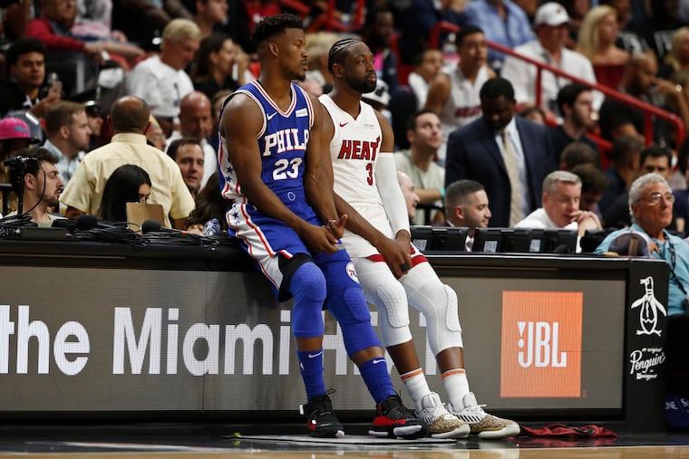 Miami Heat guard Dwyane Wade (3) and Philadelphia 76ers guard Jimmy Butler (23) wait to play in the first half of an NBA basketball game on Tuesday, April 9, 2019, in Miami. (AP Photo/Brynn Anderson)