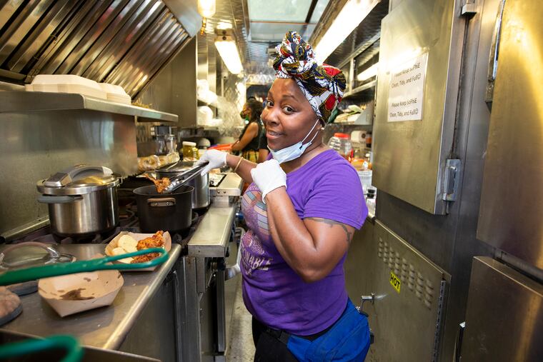 Chef Nia D Minard is running SEAMAAC's popup So.phi.e (South Philadelphia East) Food Truck and selling Mississippi hot tamales, which she grew up eating, and other dishes. She briefly drops her mask for a photo while working in the food truck on July 22, 2020.