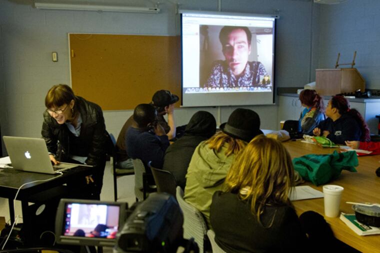 Fine Arts professor Elizabeth Demaray (left at computer) leads a SkypeOnArt session with Serbian artist Milos Tomic, on the screen. The class was being held in the Fine Arts Building, Rutgers University, Camden, on Nov. 4, 2013. (DAVID M WARREN/Staff Photographer)