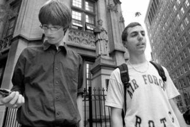 Members of the last class of Cardinal Quigley Preparatory Seminary - John Reed (left), 16, and John Anscheutz, 17 - leave the Chicago high school. It has closed for good.