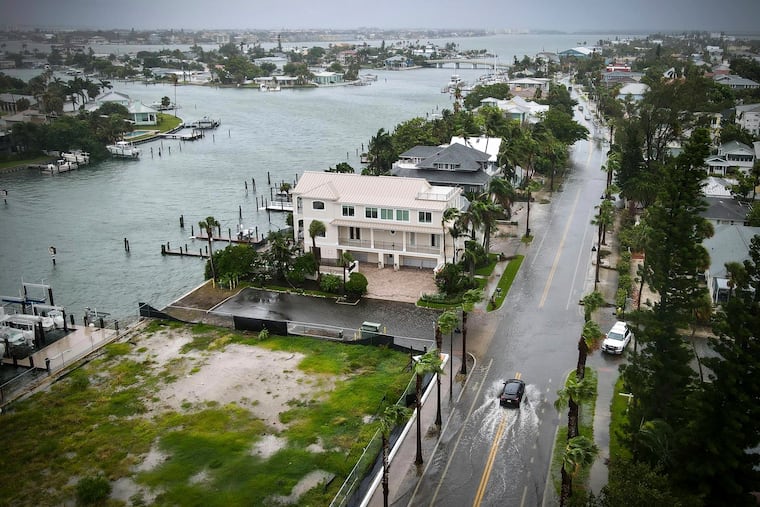 A car drives on a flooded street as Tropical Storm Debby passes just to the west of the Tampa Bay, Fla., region, on Sunday, Aug. 4, 2024. Debby made landfall Monday in northern Florida as a Category 1 hurricane.