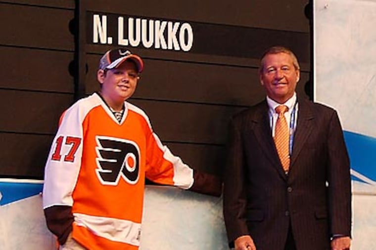 Flyers president Peter Luukko (right) and son Max (left) watched the Flyers draft Luukko’s older son Nick. (Photo by Zack Hill)