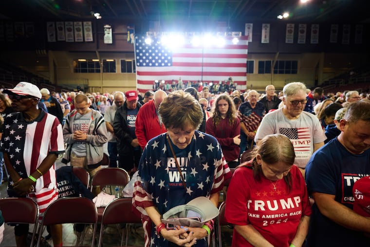 Supporters of Donald Trump are shown praying during a rally in Erie in July 2023.