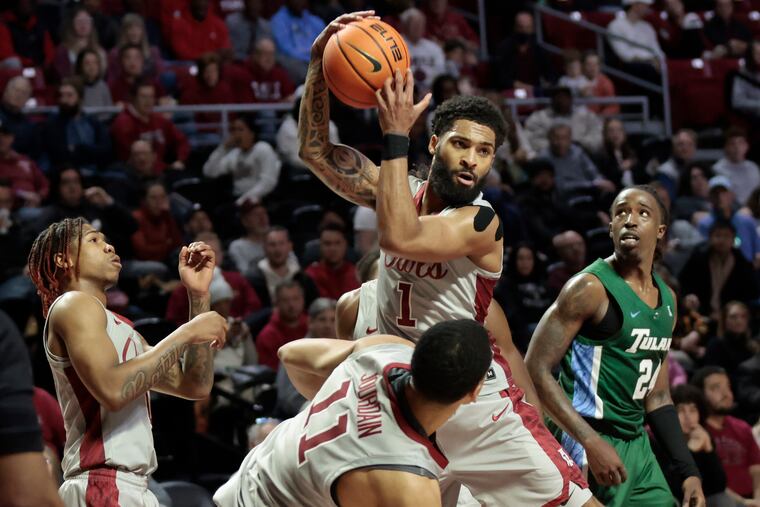 Temple's Damian Dunn, pictured at center in a game earlier this season against Tulane, led the Owls with 21 points in a regular season-ending loss to the Green Wave on Sunday.