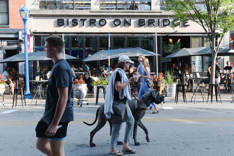 Hundreds of people, some walking dogs, are drawn to Bridge Street checking out the summer scene in Phoenixville on Friday, July 1.