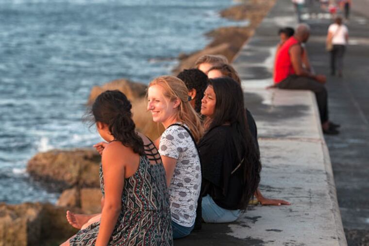 Student participants in Arcadia University’s semester abroad in Havana, including Janelle Crilley (second from left) and Jessica Perez (third from left), enjoy a sunset. Many U.S. colleges offer Cuban study; only Aracadia has a presence in fall, spring, and summer. (CLEM MURRAY / Staff Photographer)