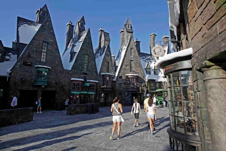 Visitors stroll the streets of Hogsmeade in the Wizarding World of Harry Potter. Harry has conjured up big bucks for Universal.