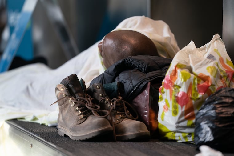 Willie Warren sleeps on a baggage carousel at the Philadelphia International Airport, early in the morning, in Philadelphia, May 21, 2020. Warren works during the day as a demolition and concrete contractor. He has been staying at the airport for several weeks. He hopes to be matched with a place to stay by homeless outreach coordinators.