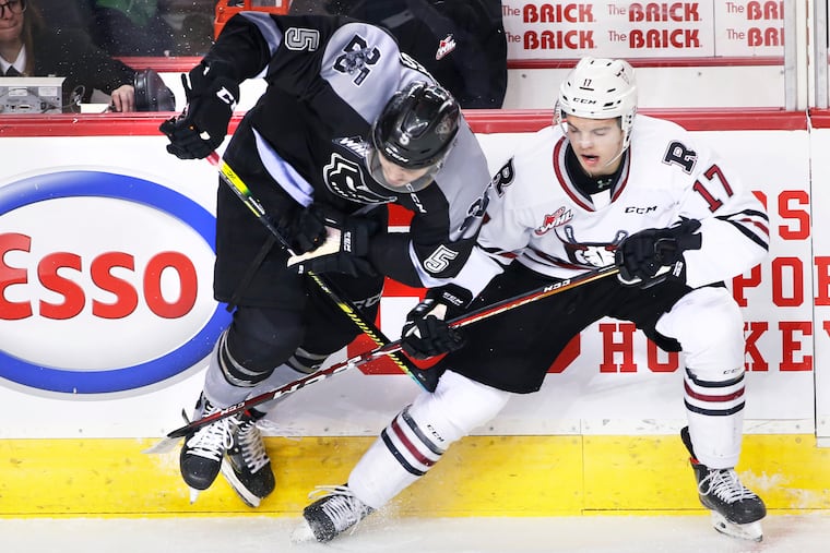 Calgary Hitmen defenseman Jackson van de Leest (left) battling for the puck during Western Hockey League action against Red Deer in January 2020.