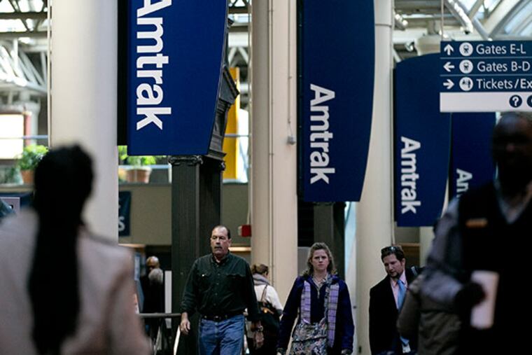 Commuters walk past Amtrak signs at Union Station in Washington, D.C., U.S., on Friday, Feb. 15, 2013. (Andrew Harrer/Bloomberg)