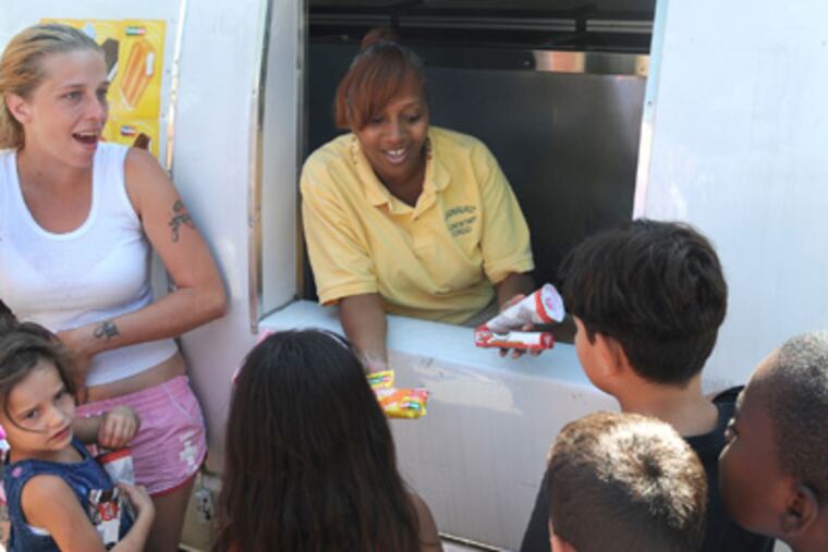Rhawnhurst Elementary School principal Karen Howell-Toomer (in the truck window), hands out free ice cream to kids in the "after school program" of the Kinder Academy located on Bustleton Ave. Thursday, Aug. 30, 2012. Northeast High VP Rob Caroselli came up with the idea to rent the Jack and Jill ice cream truck and do outreach throughout the Northeast with principals at various schools taking turns handing out the free ice cream at malls, rec centers, etc. ( CLEM MURRAY / Staff Photographer )