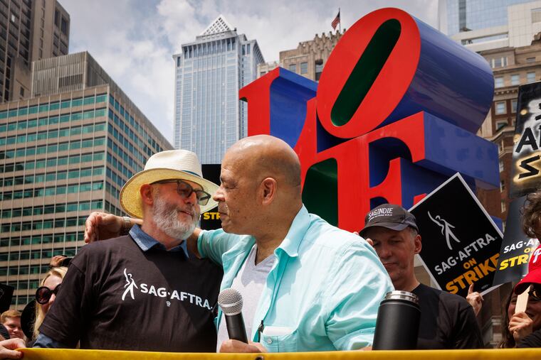 Actors David Morse and Brian Anthony Wilson embrace at the podium of the SAG-AFTRA strike in Love Park in Philadelphia.
