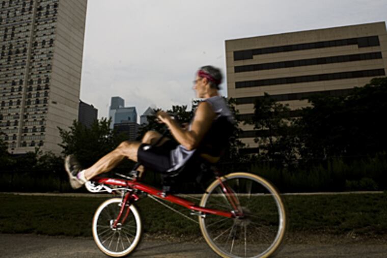 A bicyclist rides along the Schuylkill. Studies show people are cutting back on driving.