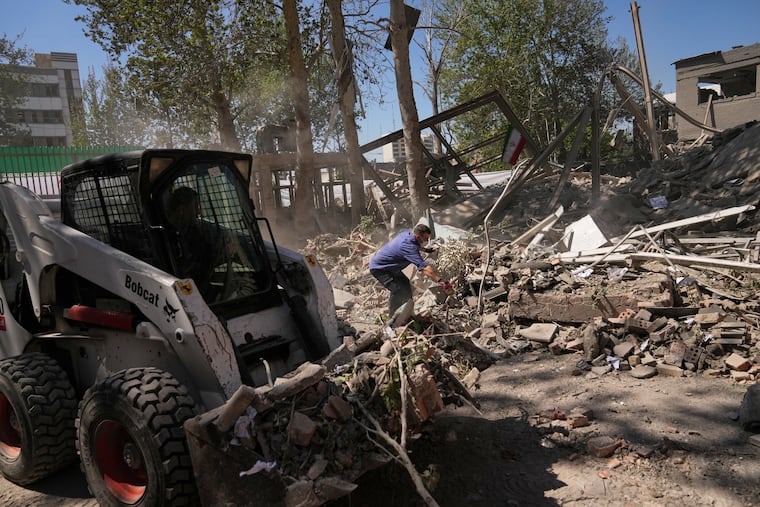 Workers remove debris at Tehran's Sharif University of Technology complex that Iranian authorities say was hit early Monday by a U.S.-Israeli strike, in Tehran, Iran.