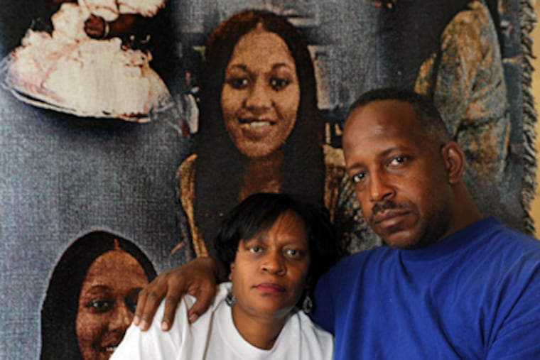 Harry III and Wilma Williams of Pennsauken, parents of Sherita Williams, in front of a memorial blanket. Their daughter was killed in 2003 in a case that went frustratingly cold. (April Saul / Staff Photographer)