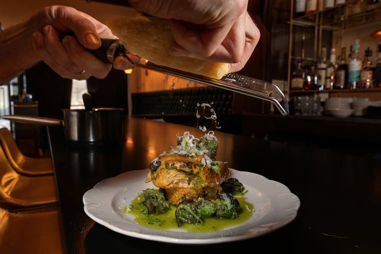Chef Alex Kemp shreds cheese on his green garlic escargot roll, the witty new star of My Loup's menu: the Esca-Roll, a roll-up bun but stuffed with buttery snails. Think: Cinnabon meets escargot. Tuesday, Dec. 12, 2023.