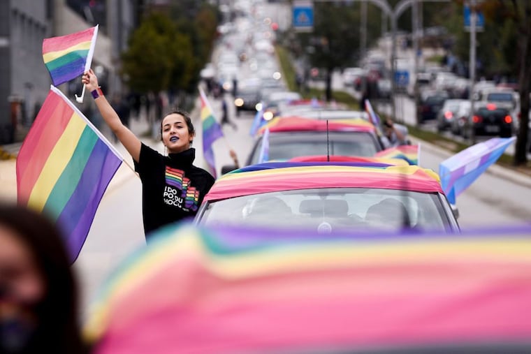 A girl waves rainbow flags as she takes part in the lesbian, gay, bisexual and transgender (LGBT) Pride Parade in Pristina on October 12, 2020.