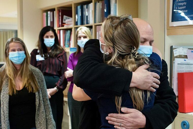 Frank Talarico hugs registered nurse Sydney Santos as his wife Christine Lynch (far left) and Virtua staff members Donna Knapp, assistant vice president of finance, and Karen Magarelli, chief nursing officer of Virtua Our Lady of Lourdes Hospital, look on.