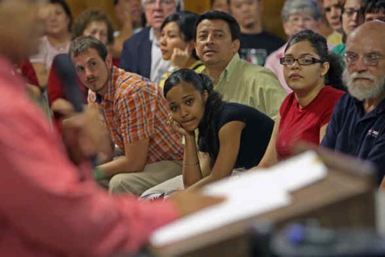 Audience members at the Sunday meeting listen to one of the speakers who shared stories about encounters with police and how the city-federal cooperation adversely affected their lives.