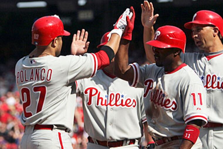Placido Polanco celebrates his seventh inning grand slam with teammates Carlos Ruiz, Jimmy Rollins and Raul Ibanez. (Yong Kim / Staff Photographer)