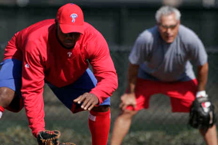 Sam Perlozzo, 57, top, will coach the infielders throughout spring training. He is working with first basemanRyan Howard, below, of whom he says: "He's not satisfied just being an offensive player."