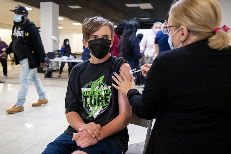 Logan Hardel, 13, of King of Prussia, gets vaccinated at the Montgomery County coronavirus vaccination site at King of Prussia Mall.