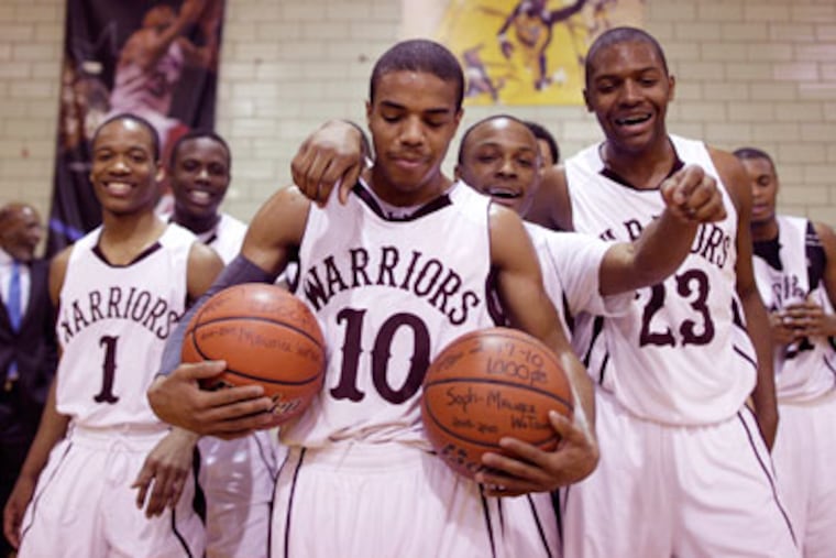 Maurice Watson is surrounded by teammates after he
scored his 2,000th point. (Michael S. Wirtz/Staff Photographer)
