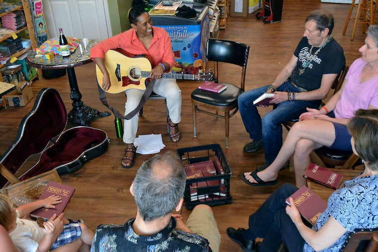 Sandra Lawson (top left), a rabbinical student, holds a Shabbat Service at Arnold's Way Cafe in Lansdale. Lawson won a grant to develop Jewish programming in nontraditional places. Pictured from the right of Sandra are cafe owner Arnold Kauffman and Sandra's wife Susan Hurrey.