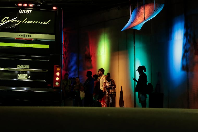 Travelers wait to board a Greyhound bus under the Interstate 95 overpass on Spring Garden Street, near North Second Street, in Philadelphia in 2024.
