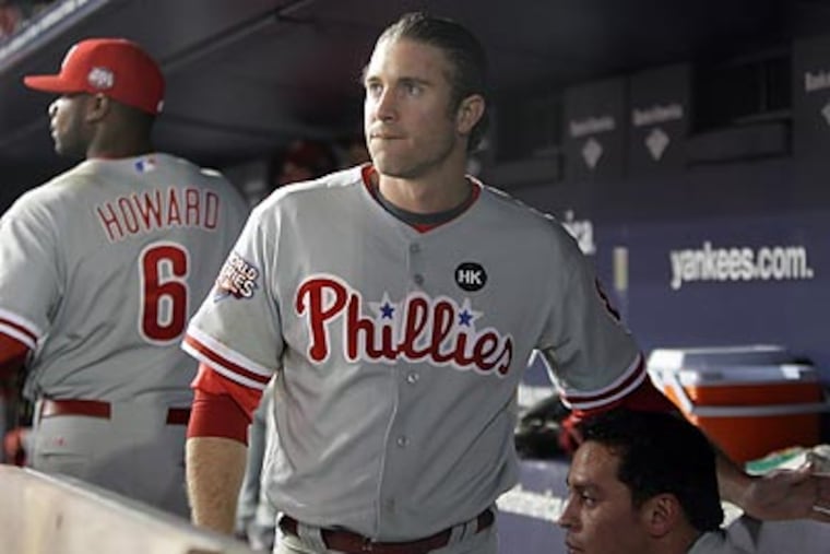 Chase Utley watches from the dugout as the Yankees celebrate. Utley struck out in a key at-bat during the seventh inning. (Yong Kim/Staff Photographer)