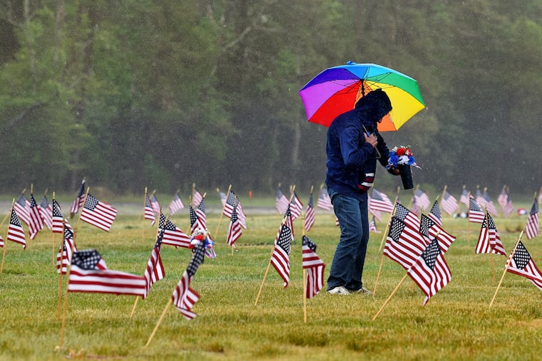 Joyce Winkler places flowers on graves after doing the same for her husband’s at the Atlantic County Veterans Cemetery in Estell Manor on Sunday.