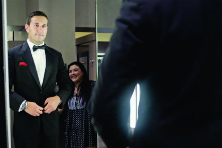 Nick Dobin tries on his rental tuxedo during his final fitting on July 2, 2015, inside Men's Wearhouse in Center City. (BEN MIKESELL / Staff Photographer)