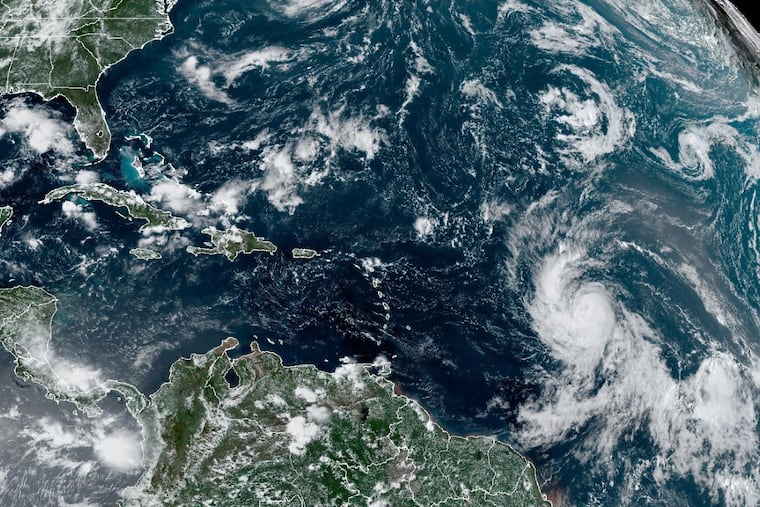 This Wednesday satellite image shows Hurricane Lee (right) off in the central tropical Atlantic Ocean.