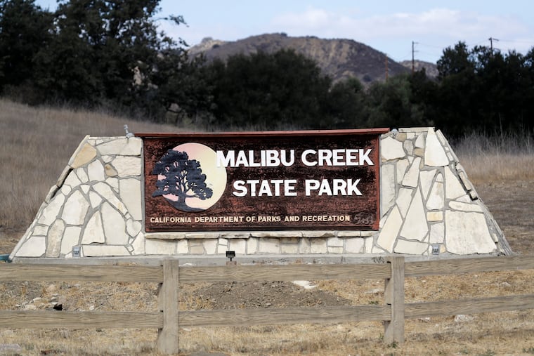 FILE - In this Oct. 11, 2018 file photo a sign is seen at the entrance to the Malibu Creek State Park in Calabasas, Calif. The arraignment of a parolee charged with killing a man camping with his daughters at a Southern California state park in June and shooting at 10 people over the past two years has been postponed. Prosecutors said Monday, Jan. 7, 2019, that arraignment for Anthony Rauda was continued until Jan. 22 in Los Angeles County Superior Court. (AP Photo/Marcio Jose Sanchez,File)