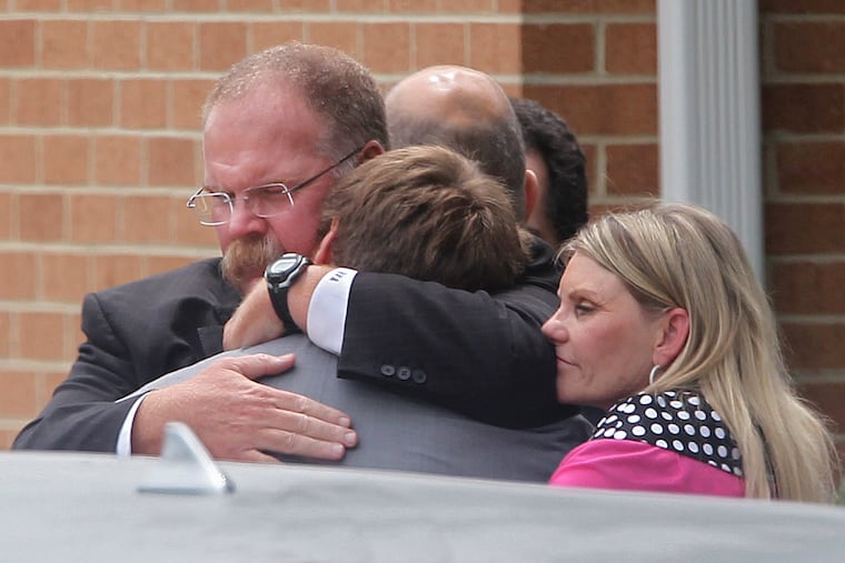 Then-Eagles head coach Andy Reid gives his son Britt a hug along with wife, Tammy, after the memorial service for Garrett Reid in 2012.