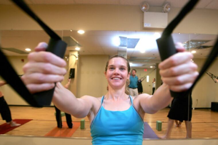 Larissa Pluta uses the aeroSling at Verge Yoga. She says it has helped her strengthen and heal an injured shoulder. (David Swanson / Staff Photographer)